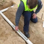 Professional Plumber Laying Underground Pipe
